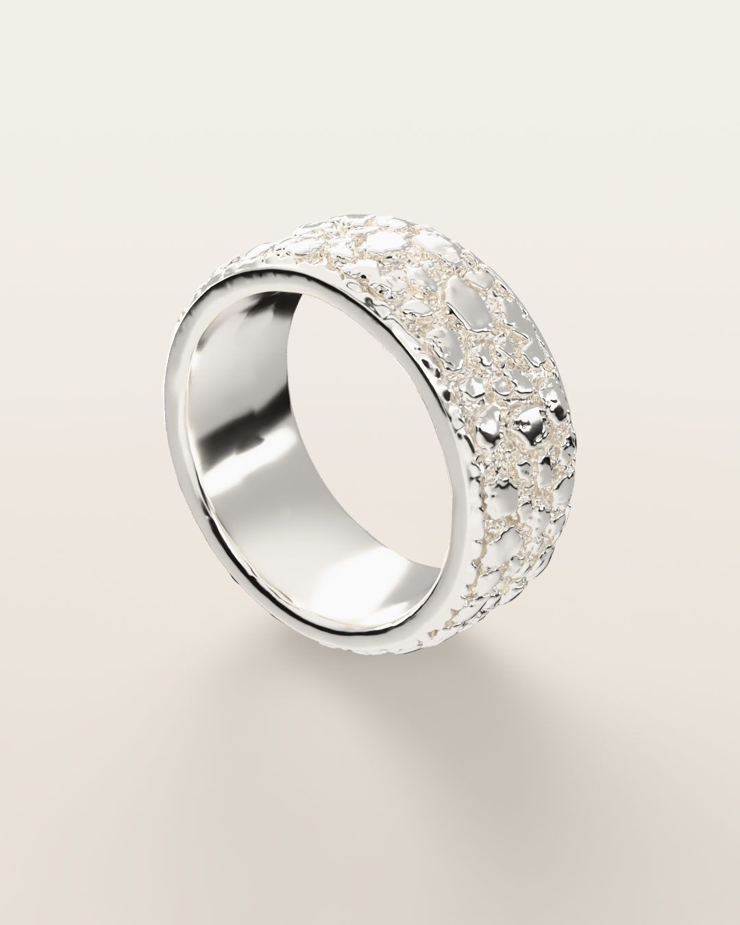 No. 508 Placer nugget ring, turning slowly under a low light, sterling silver, rendered from the production 3D file