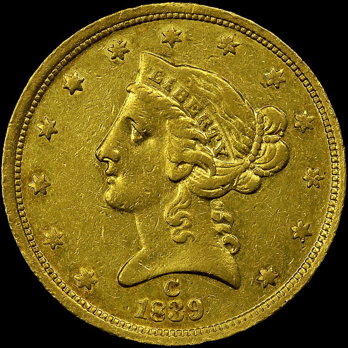 A worn gold five-dollar coin with a Liberty head, the letter C above the date 1839
