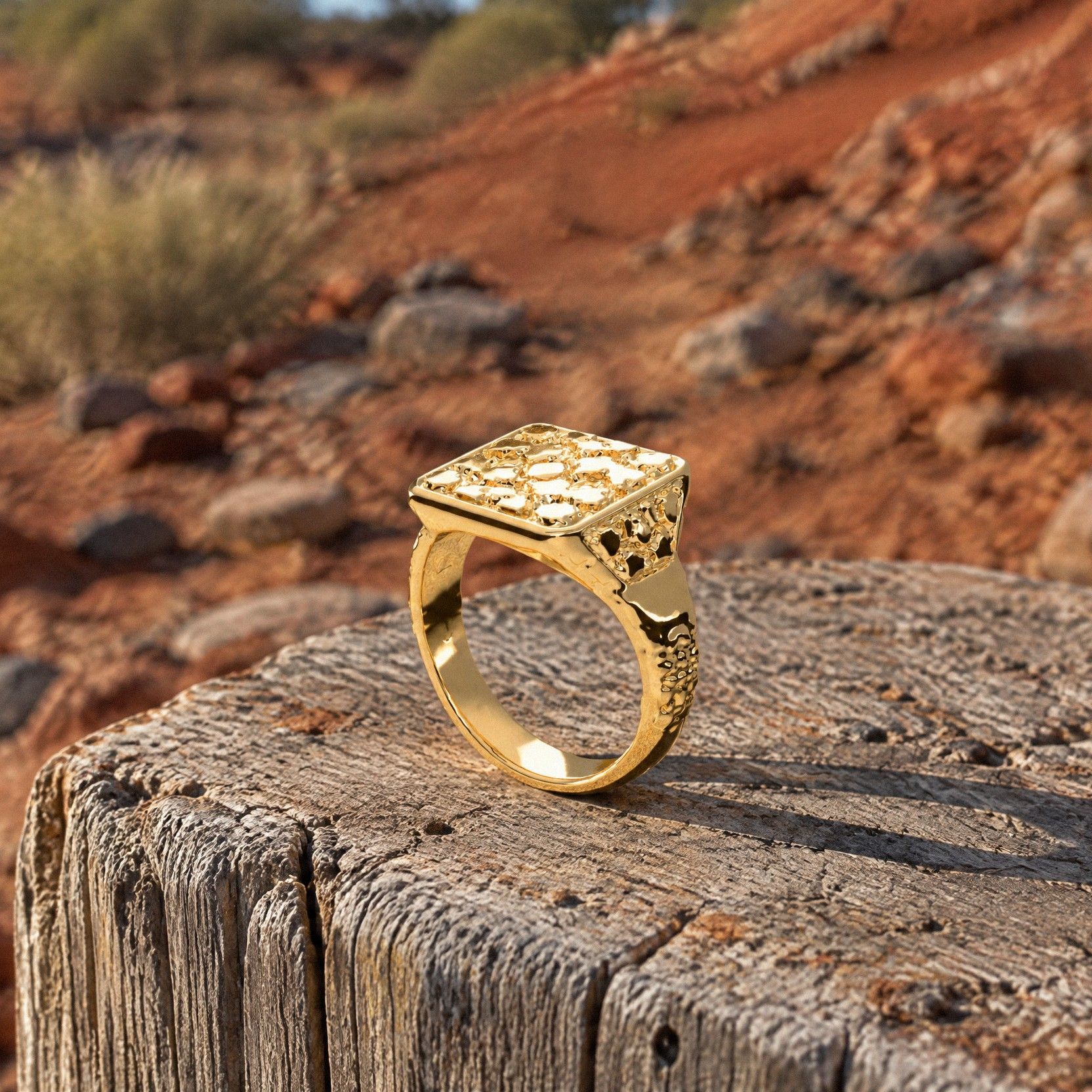 No. 432 Signet L nugget ring in 14K yellow gold, on the sawn top of a weathered timber claim post