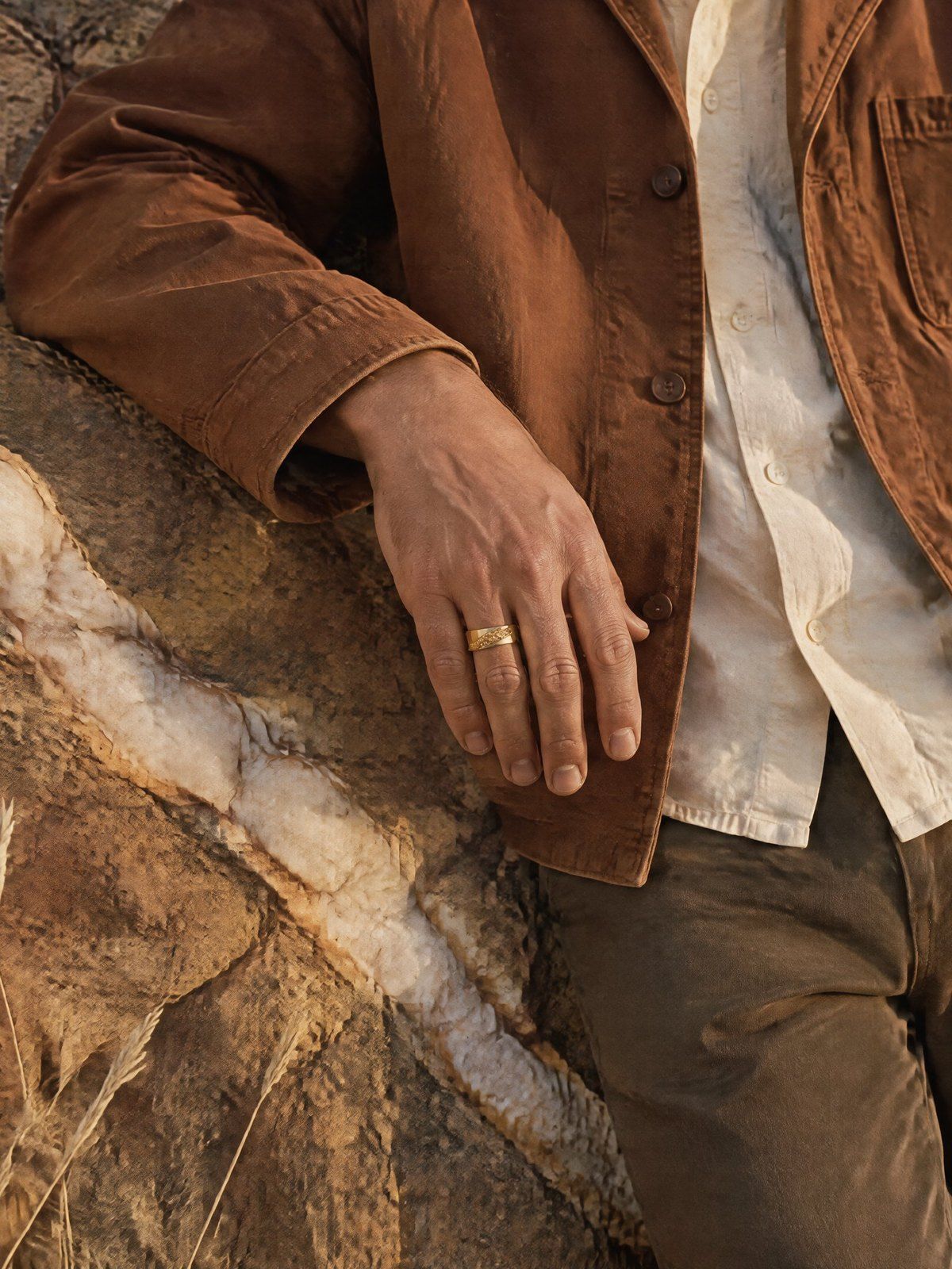 Fault Line No. 518 in solid 14K gold, a hand on an ochre rock face crossed by a white quartz vein