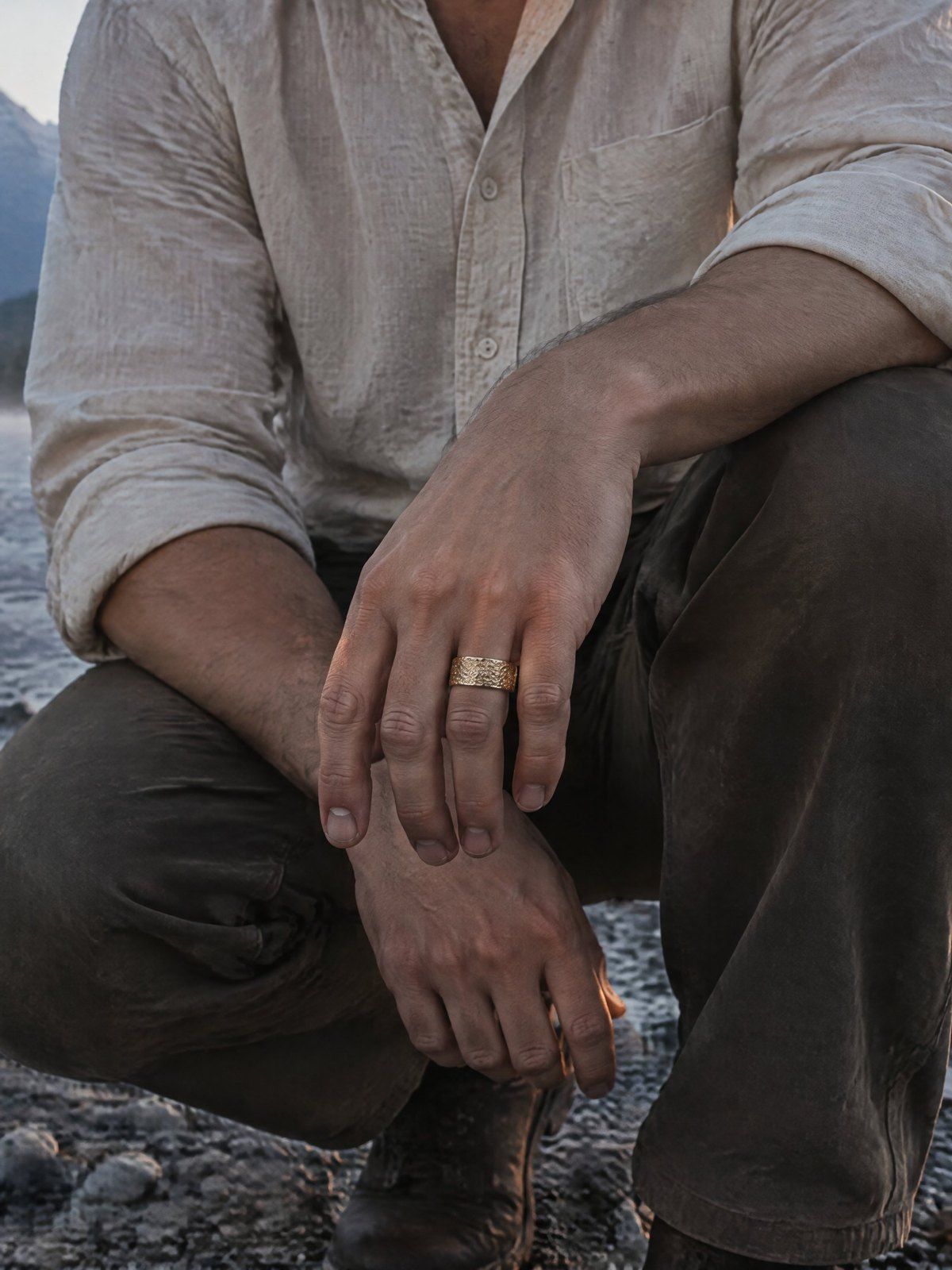 Placer No. 508 in solid 14K gold, worn by someone crouched at the edge of a creek at dawn