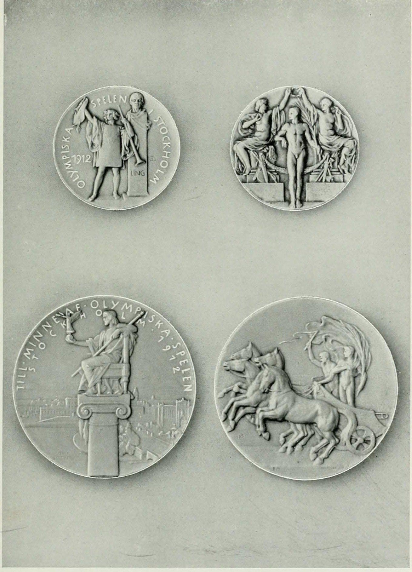 A printed plate of four medals on a grey ground: two small prize medal faces at the top, two larger commemoration medal faces below